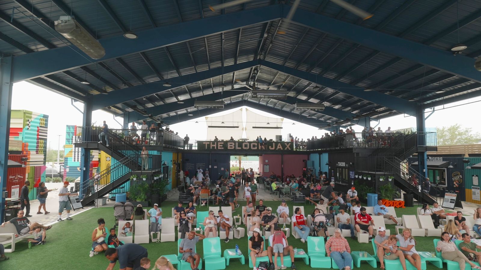 Guests filling the lawn seating under the open-air pavilion at The Block Jax food hall in Jacksonville, Florida