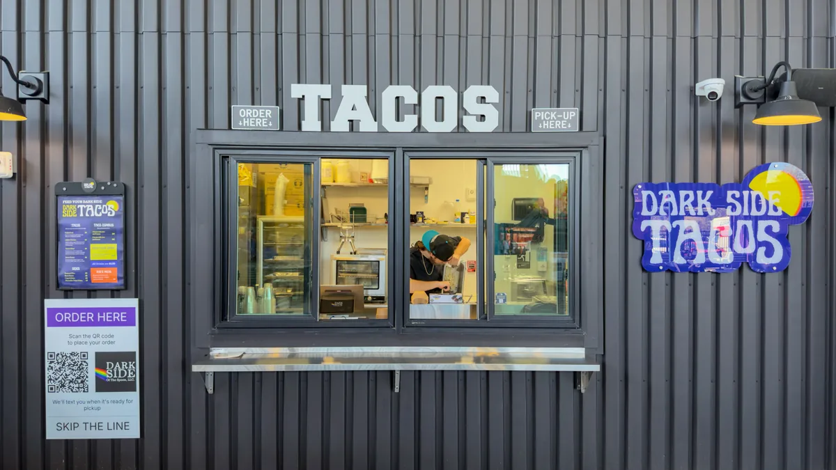 Mobile ordering food hall POS system: vendor window with a scan to order QR code sign